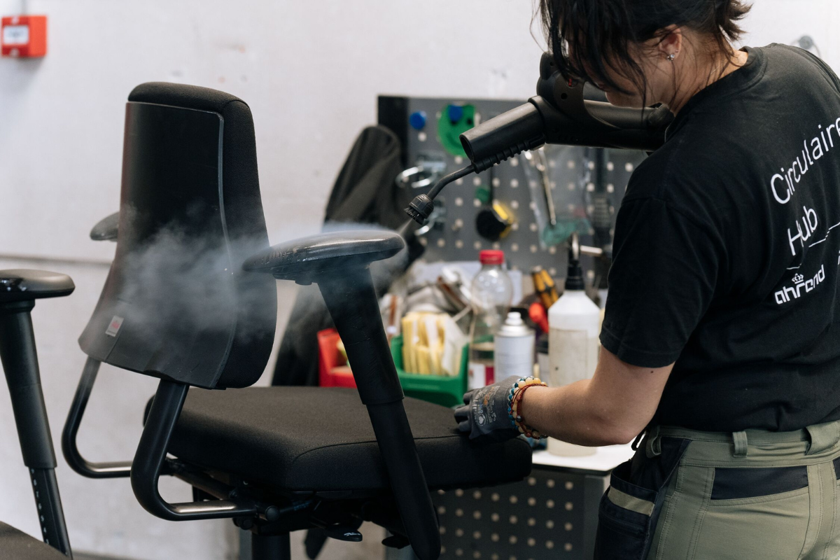 Person saeubert einen gebrauten Buerostuhl