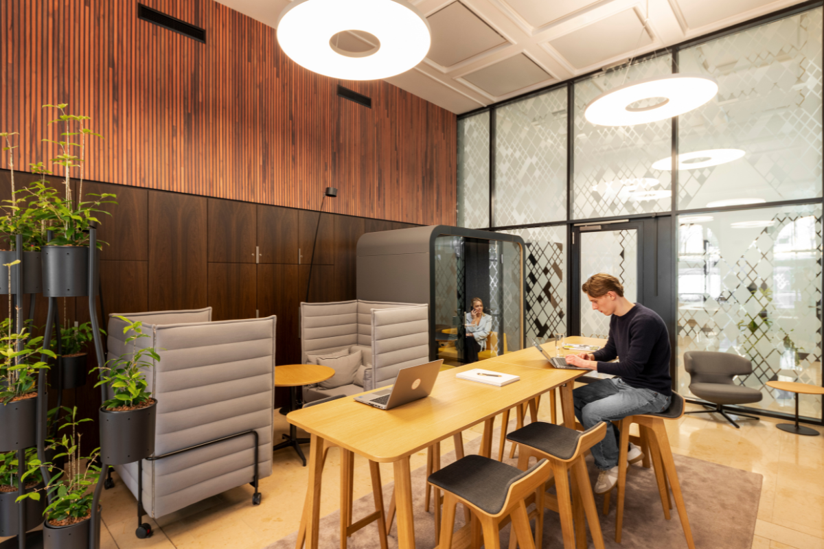 Zwei Personen sitzen an einem flexiblen Arbeitsplatz im Buero