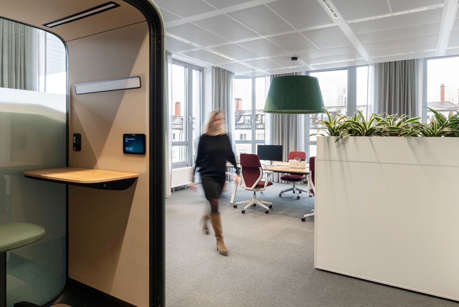 Mitarbeitende geht durch die Bürofläche von Haleon in München, geplant und eingerichtet von designfunktion