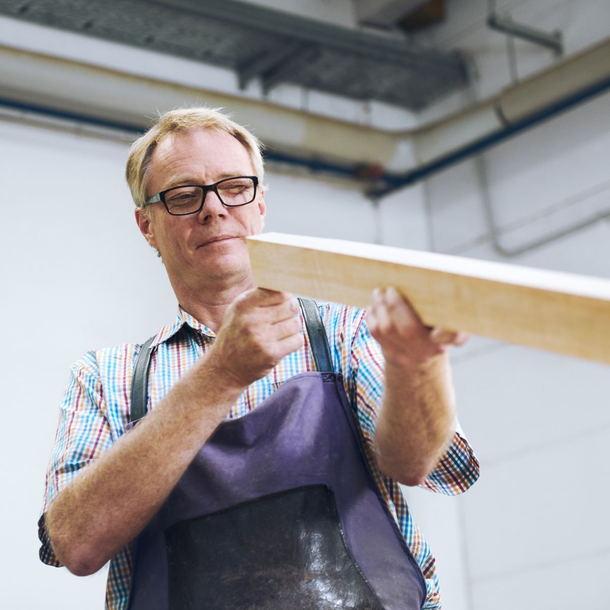 Mitarbeiter von COR begutachtet Holz für die Möbelproduktion