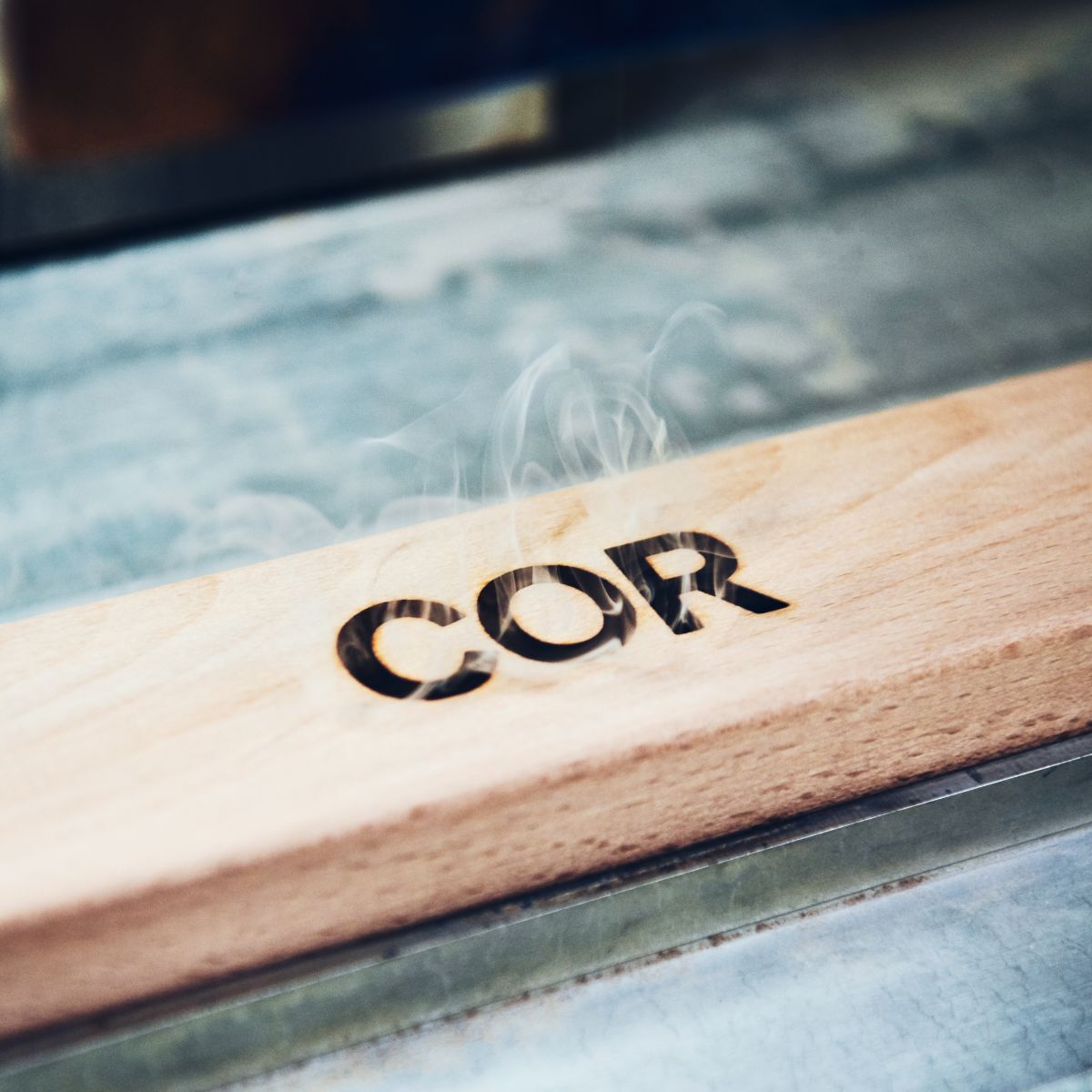 in Holz eingebranntes Logo des Möbelherstellers COR