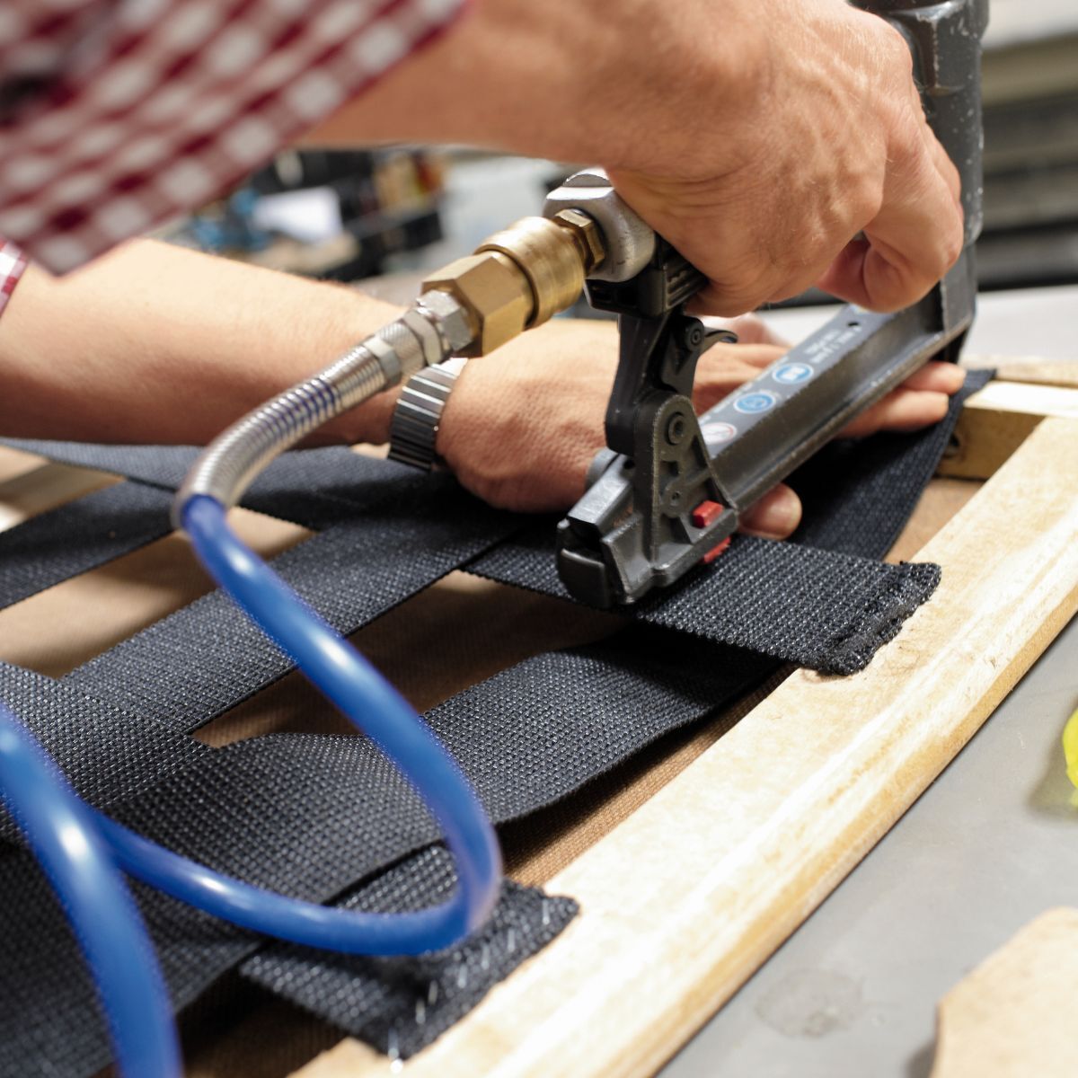 Bespannung eines Untergestells aus Holz beim Möbelhersteller COR