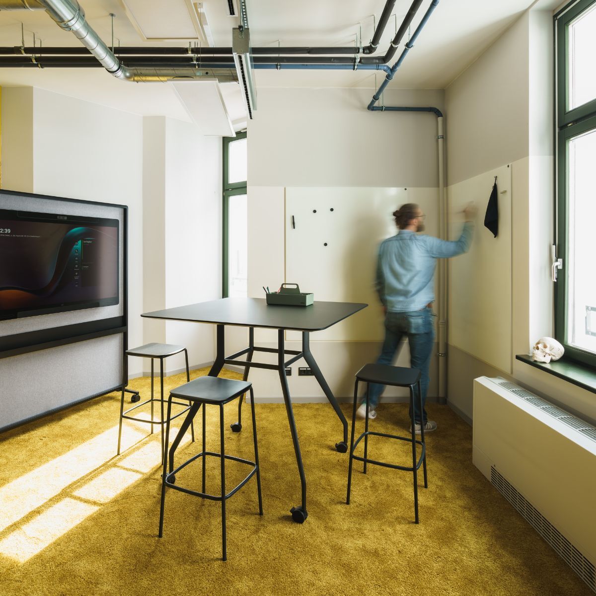 Meetingraum mit Bildschirm und Whiteboard im Geschäftsbereich IT der Charité, geplant und eingerichtet von designfunktion