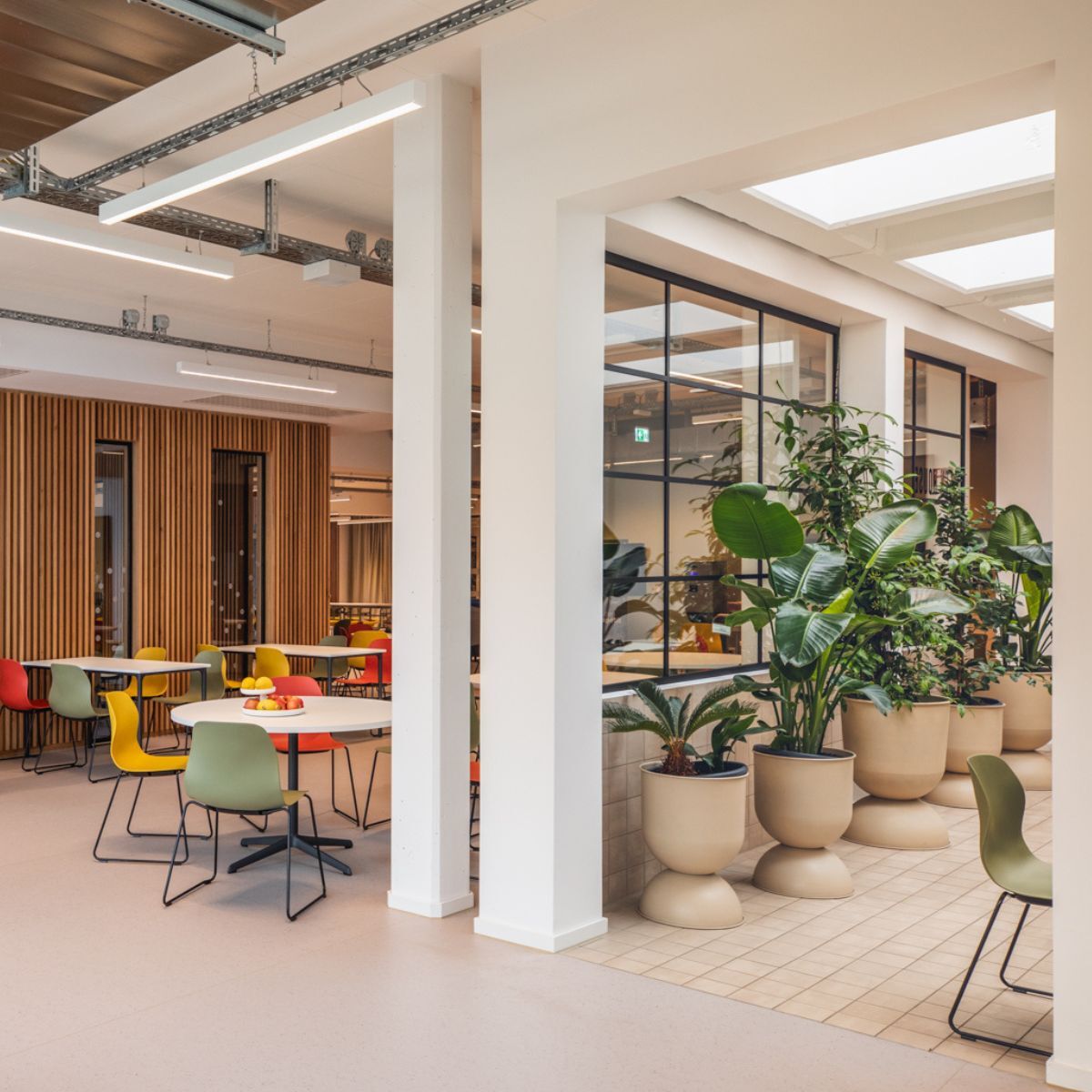 Glastrennwand zwischen zwei Bereichen der Cafeteria der Frankfurt International School, geplant und eingerichtet von designfunktion