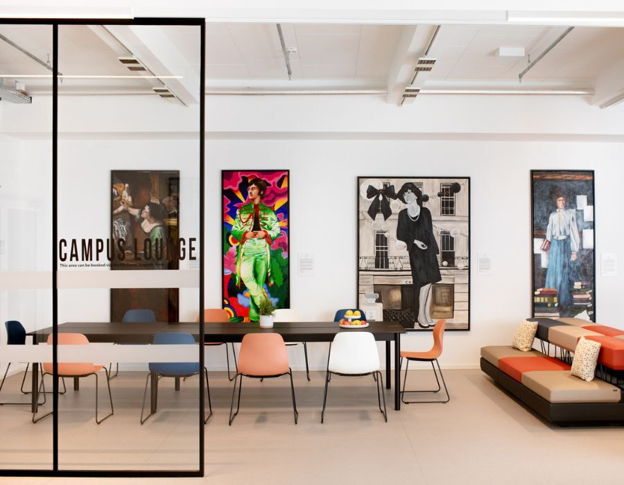Campuslounge mit Gemälden und Sitzgelegenheiten in der Cafeteria der Frankfurt International School, geplant und eingerichtet von designfunktion