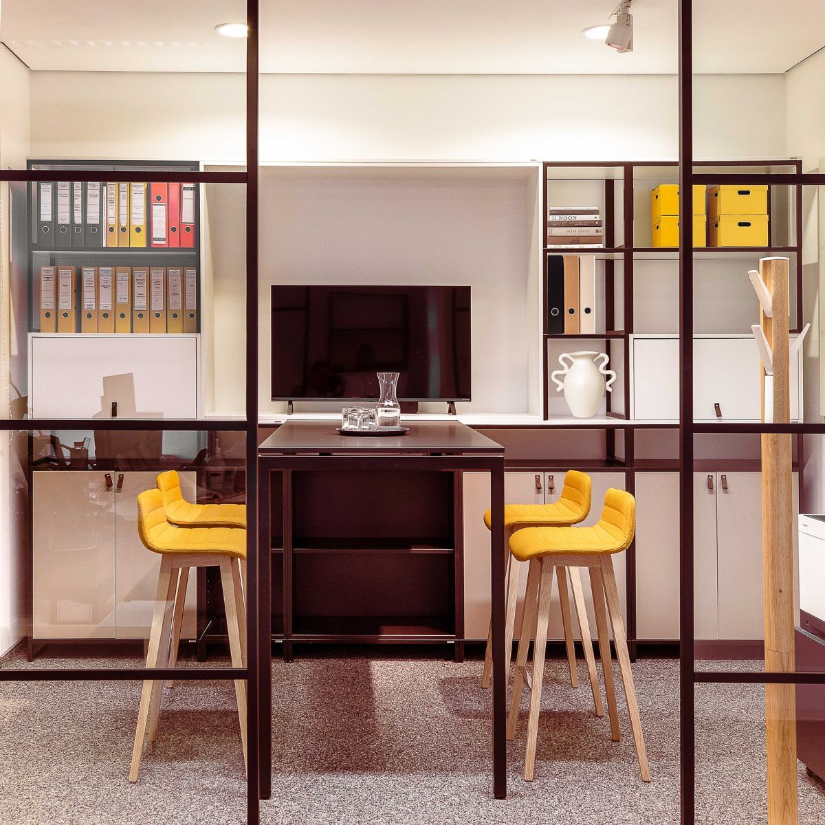 Besprechungsbereich mit Stauraummöglichkeiten, Hochtisch und Stühlen im Büro der Schulleitung der Frankfurt International School in Oberursel, geplant und eingerichtet von designfunktion