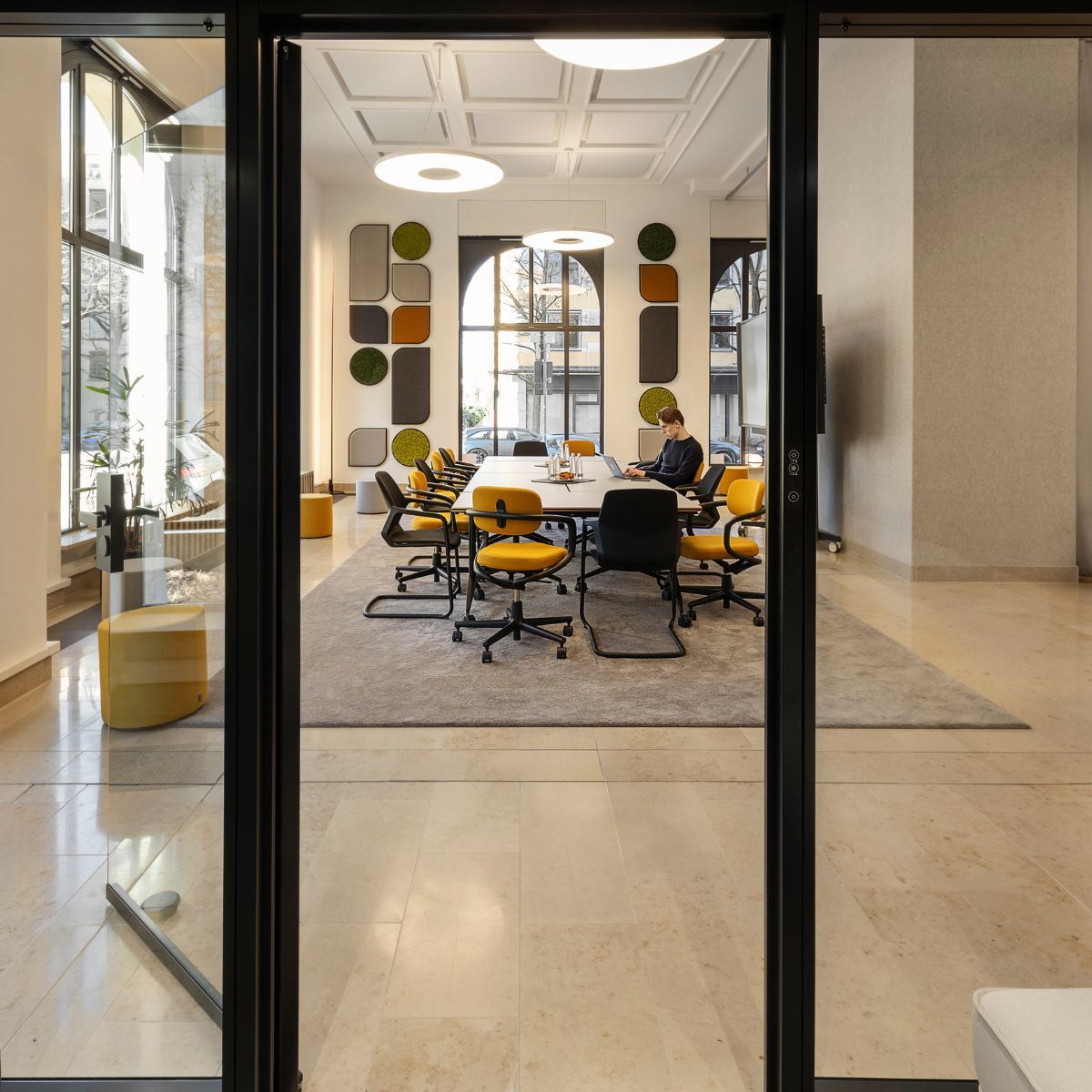 Blick aus Raum-in-Raum-System auf den angrenzenden Besprechungstisch im Co-Working Bereich der IHK München und Oberbayern, geplant und eingerichtet von designfunktion