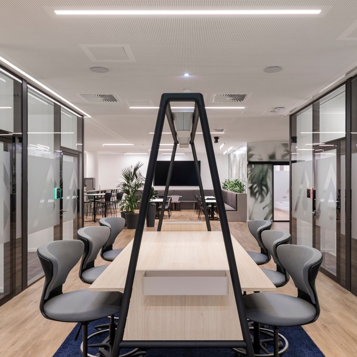 Blick auf Coworking-Bereich mit angrenzenden Fokus-Arbeitsplätzen in der neuen Arbeitswelt der Immobilien Freistaat Bayern, Beratung und Planung designfunktion München