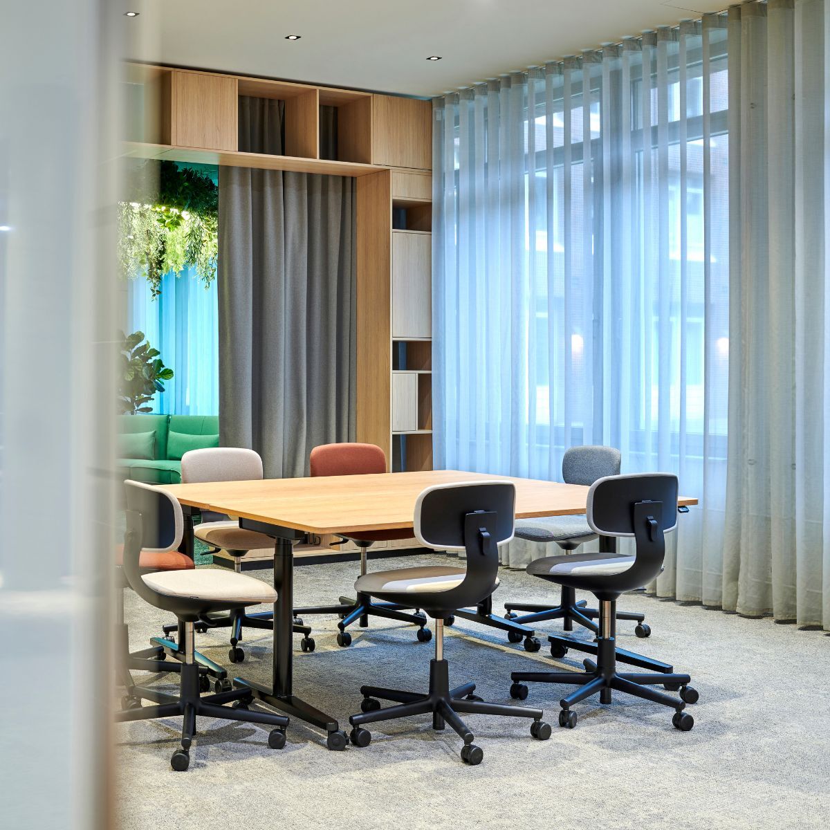 Tisch mit Stühlen im variabel nutzbaren Gemeinschaftsbereich eines Jobcenter, geplant und eingerichtet von designfunktion