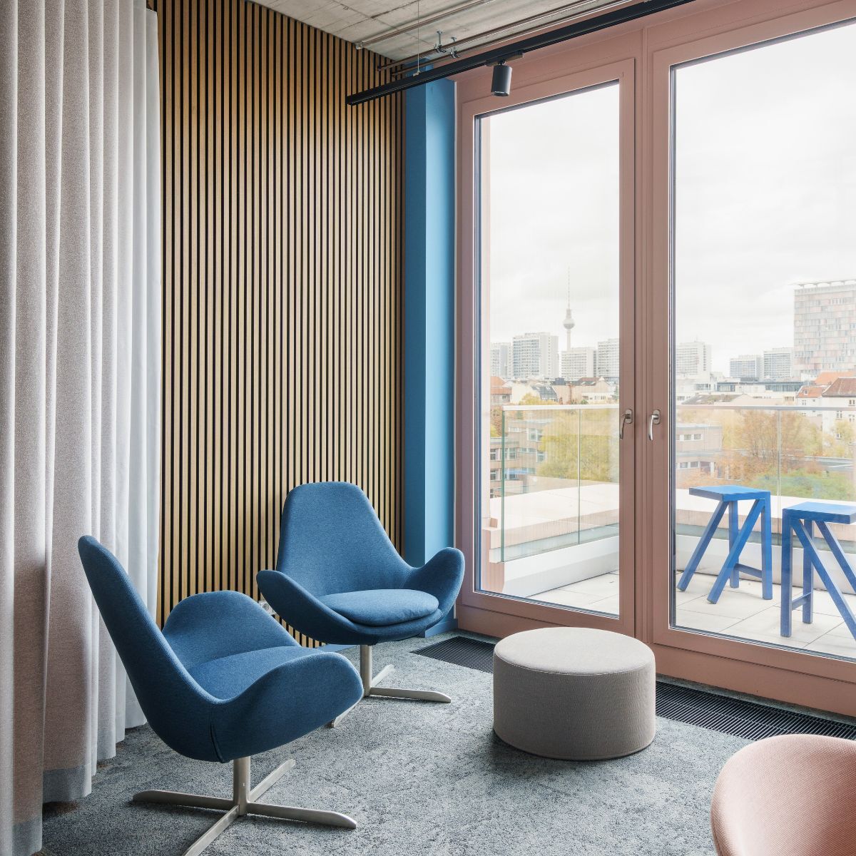 Loungemöbel vor bodentiefen Fenstern in der neuen Arbeitswelt von Johanssen + Kretschmer, geplant und eingerichtet von designfunktion