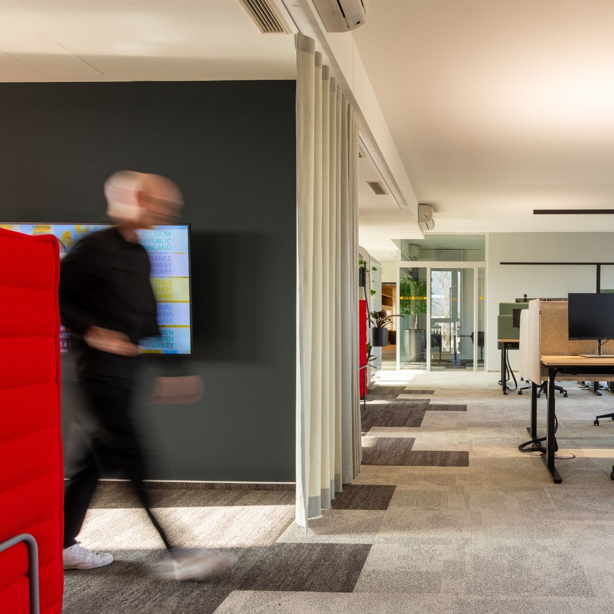 Mann geht durch die neue Arbeitswelt eines Logistikdienstleisters, geplant und eingerichtet von designfunktion