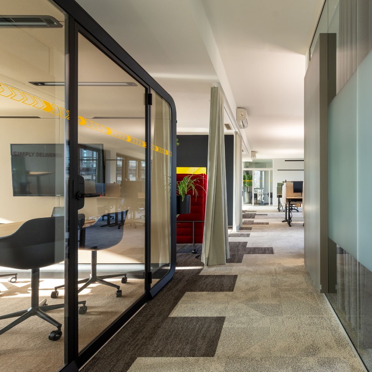 Blick in die neue Arbeitswelt eines Logistikdienstleisters mit unterschiedlichen Arbeitsplatzangeboten und Akustikvorhängen, geplant und eingerichtet von designfunktion