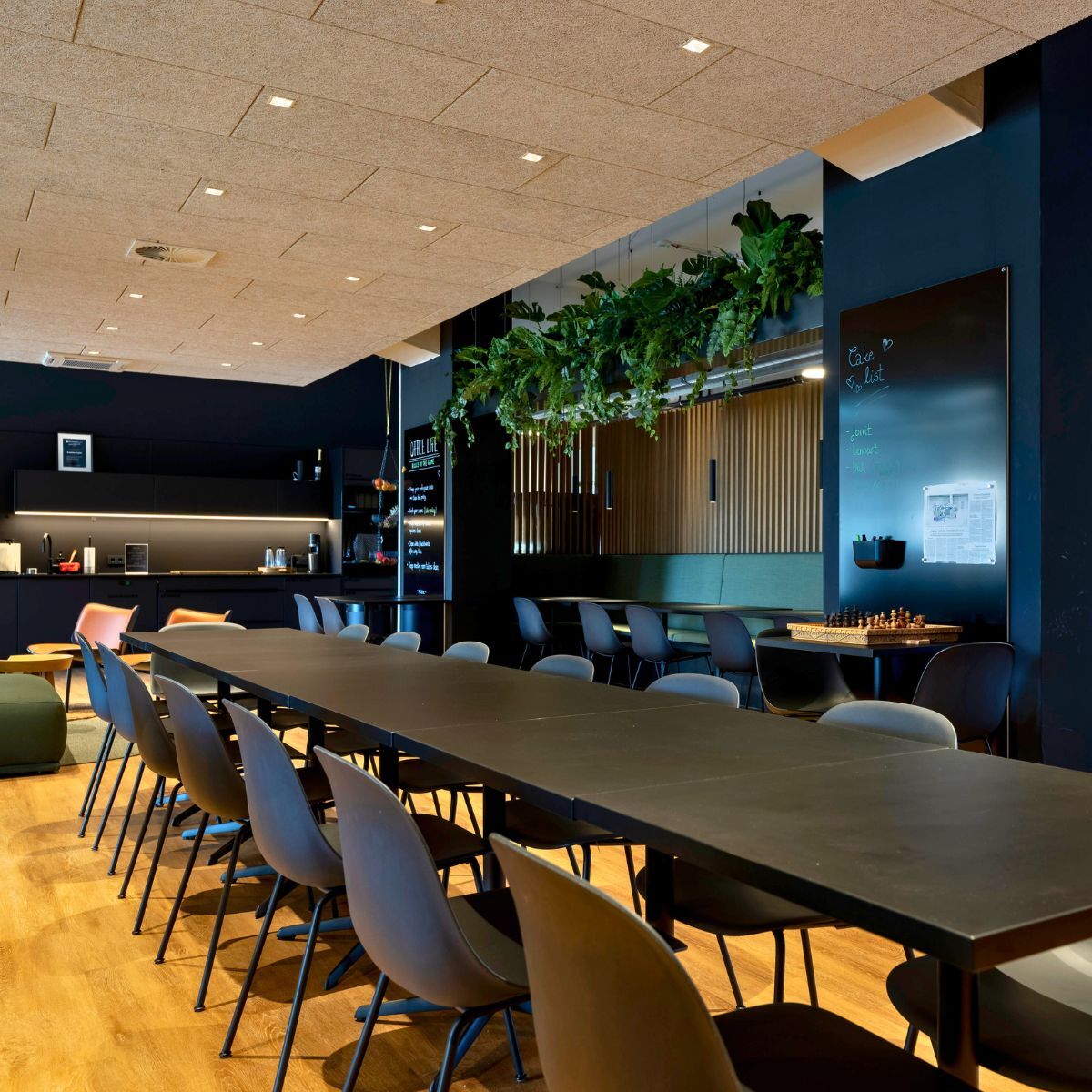 langer Tisch mit Stühlen im Mitarbeiter Café im Headquarter von Proxima Fusion, konzipiert und eingerichtet von designfunktion
