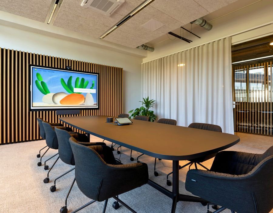 Meetingraum mit großem Tisch und Bildschirm im Headquarter von Proxima Fusion, konzipiert und eingerichtet von designfunktion