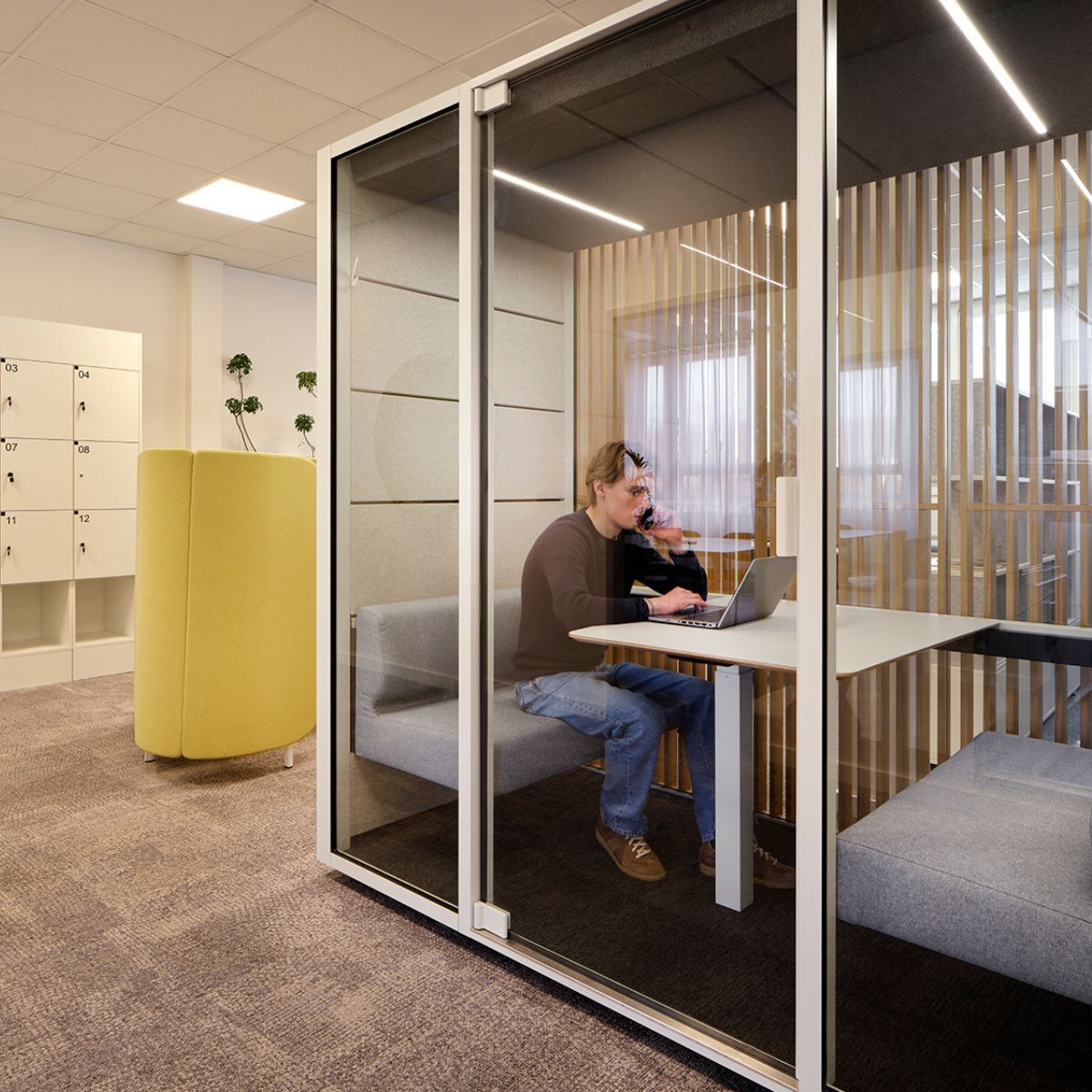 Mitarbeiter in kleiner Besprechungsbox in der neuen Arbeitswelt der SOS Kinderdörfer in München, geplant und eingerichtet von designfunktion