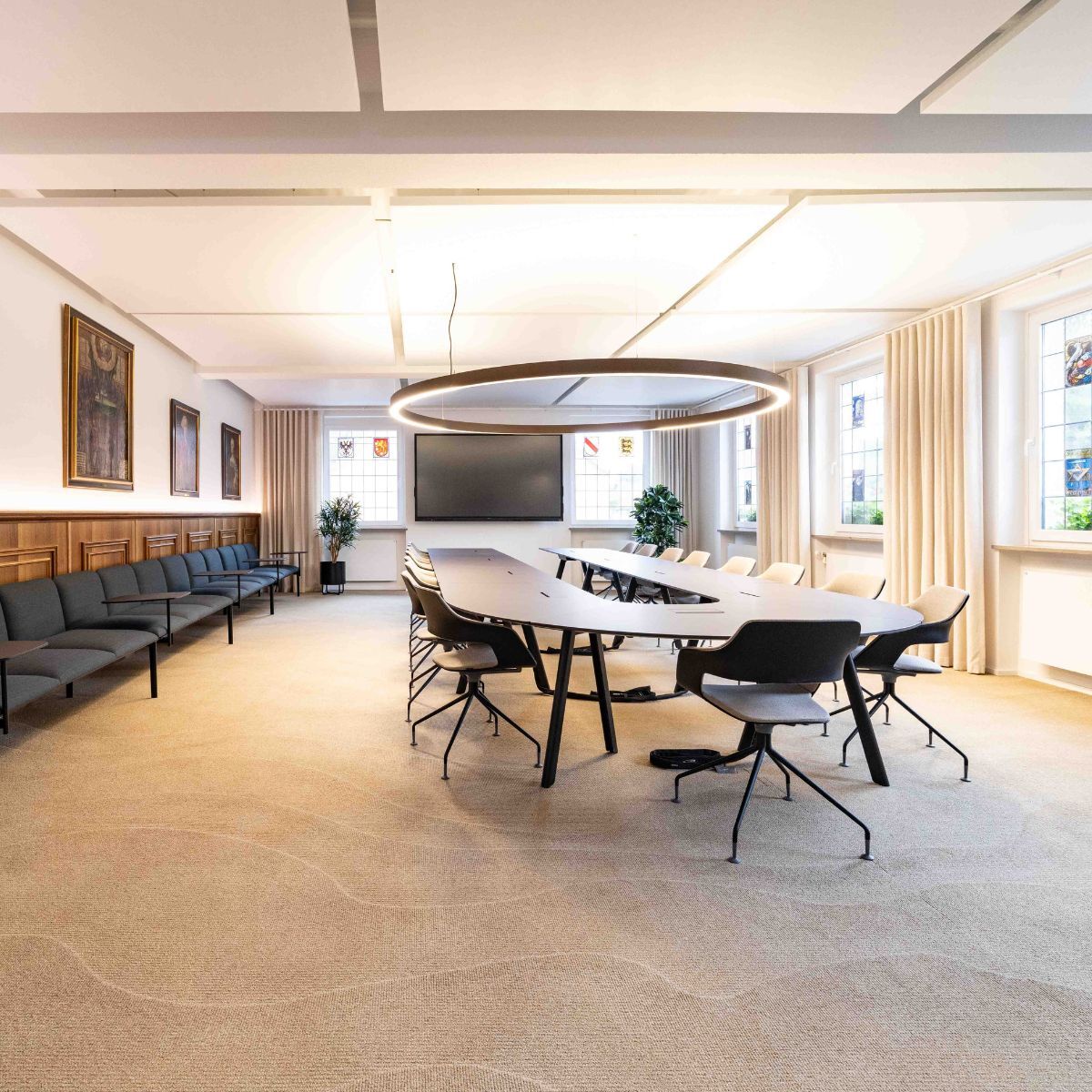 Konferenztisch mit Stühlen und lange Sitzbank im Ratssaal der Stadt Aach, geplant und eingerichtet von designfunktion