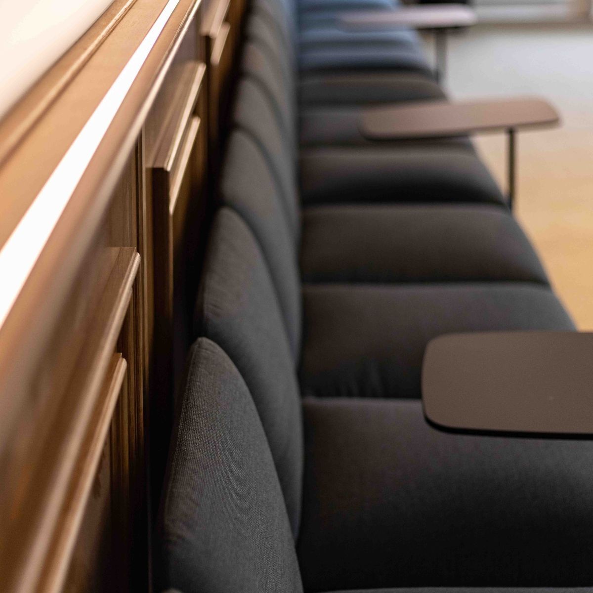 gepolsterte Sitzbank mit drehbaren kleinen Tischen im Ratssaal der Stadt Aach, geplant und eingerichtet von designfunktion