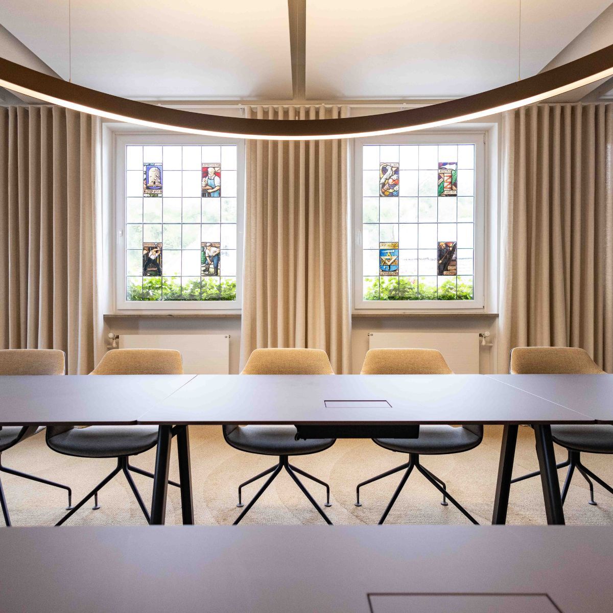 Blick auf historische Fenster und Teile des großen Konferenztisches im Ratssaal der Stadt Aach, geplant und eingerichtet von designfunktion