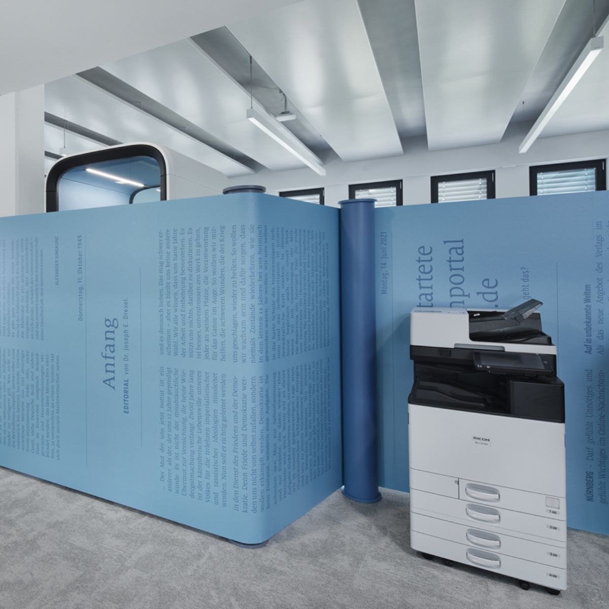 Drucker, der sich unauffällig in eine Nische der Trennwand im Verlag Nürnberger Presse einfügt, geplant und eingerichtet von designfunktion
