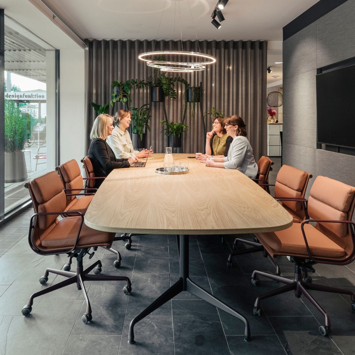 Mitarbeiterinnen an großem Besprechungstisch im neuen Schauraum von designfunktion in München